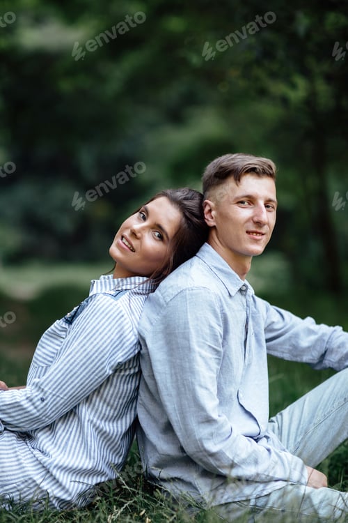 Aperçu: Plan extérieur d'un jeune couple heureux amoureux assis sur l'herbe en pleine nature. Homme et femme s'embrassant
,
