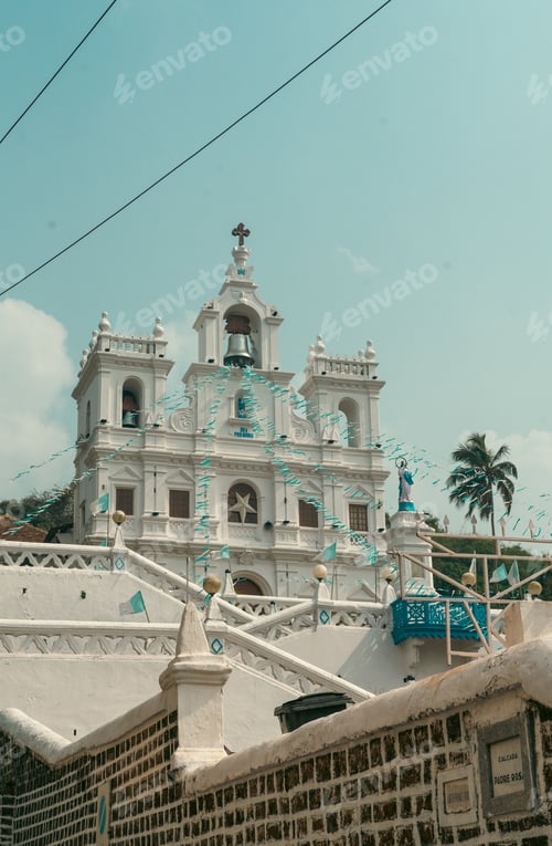 Preview: a white church with some bird in front of it and a few palm trees behind