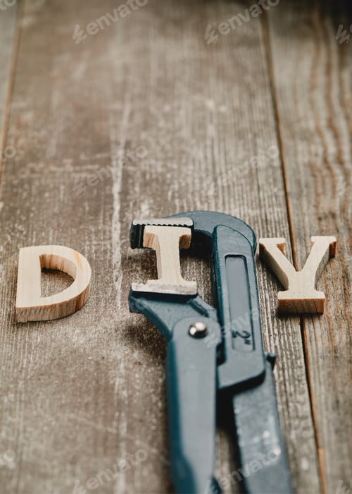 Preview: Close up of wooden diy sign and part of pipe wrench on wooden background