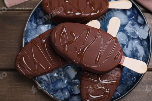 Preview: Delicious glazed ice cream bars and ice cubes on wooden table, top view