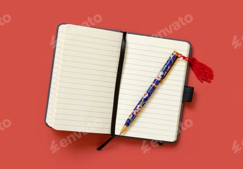 Preview: Opened ruled notebook with a ethnic pen on red table top view. Textbook mockup