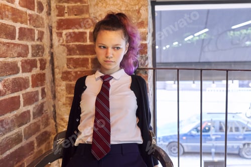 Preview: Portrait of 15 years old teenage girl in school uniform with tie sitting on chair