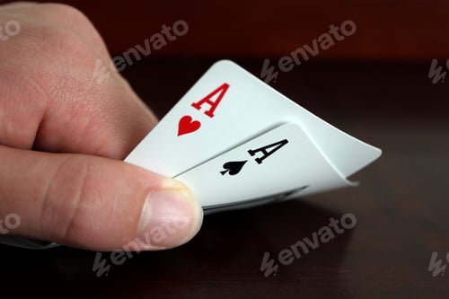 Preview: A hand of playing cards with an Ace of Hearts and an Ace of Spades between fingers