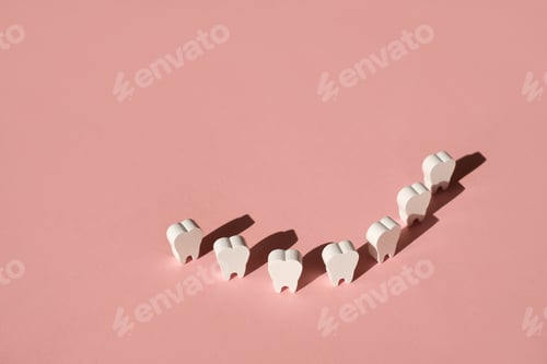 Preview: Teeth stand on a pink background in a row, forming a smile.