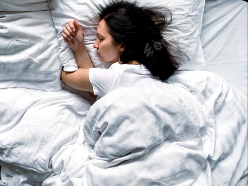 Preview: Beautiful brunette sleeping at home. Young millennial candid woman sleeps at home on a white striped