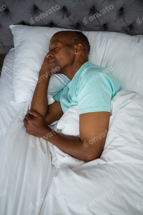 Preview: Overhead view of senior man sleeping on bed