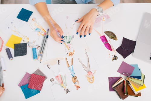 Preview: This picture describes the processes of designing clothes. There are hands of a girl drawing
