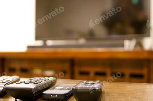 Preview: multiple remote controls lined up with TV in background