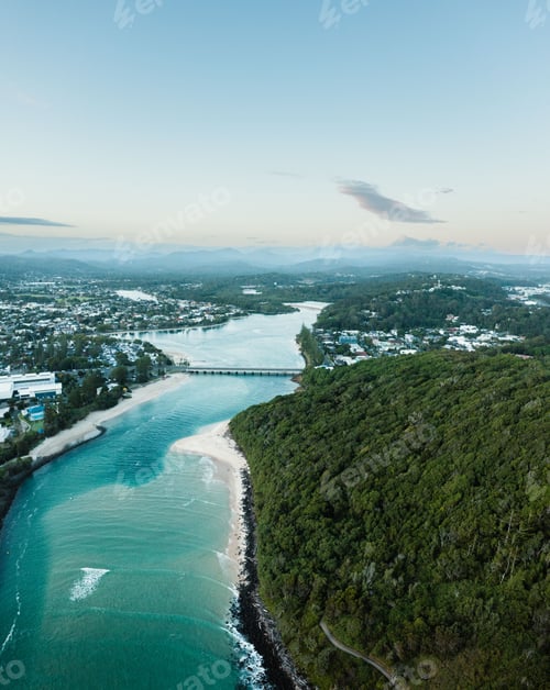 Preview: Aerial view of a scenic shoreline with lush green vegetation and residential houses on the side