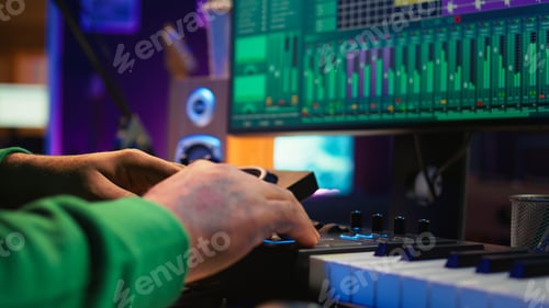 Preview: Audio engineer producing new music on mixing console in home studio