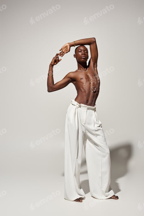 Preview: Stylish young man showcases vibrant fashion in a striking pose against a neutral backdrop