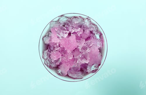 Preview: Shaving ice in martini glass on light blue background, top view