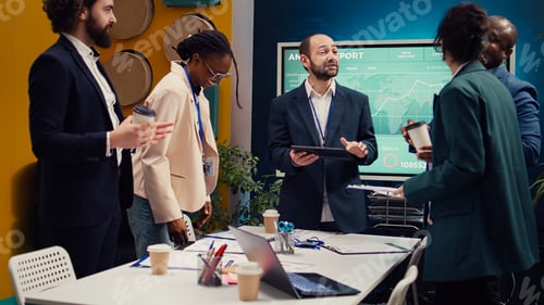 Preview: Happy confident coworkers meeting in a conference room to review their results