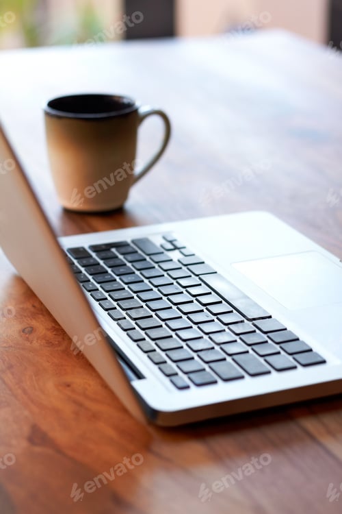 Preview: Take a break. Shot of a laptop and coffee mug on a table.