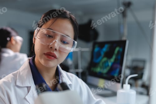 Preview: Scientist working with microscope doing research in laboratory