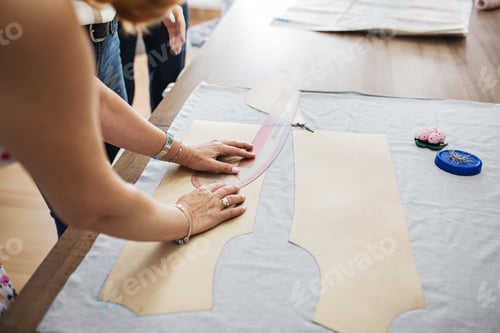 Preview: A woman with beautiful rings and bracelets is working with a sewing ruler. Fasion, tailor's