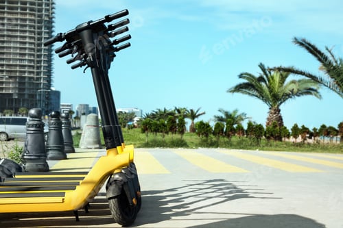 Preview: Many modern electric scooters on city street, space for text. Rental service
