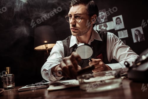 Preview: Pensive detective in glasses holding magnifier and looking away in office