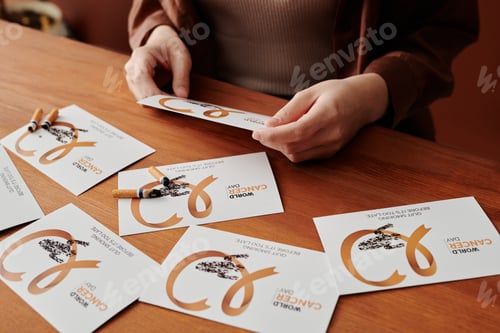 Preview: Hands of unrecognizable girl holding card with beige lung cancer symbol
