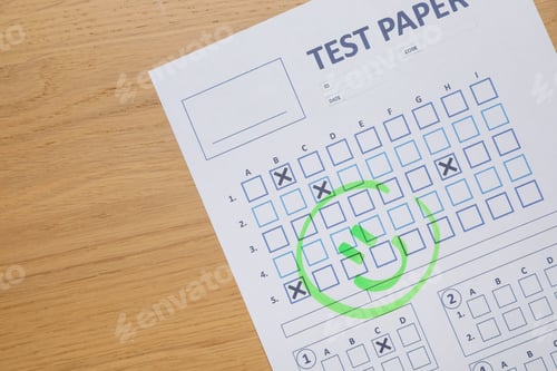 Preview: Answer sheet with drawn happy face on wooden table, top view. Student passing exam