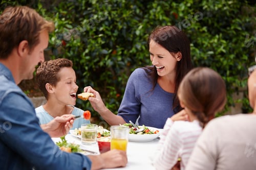 Family Enjoys Food Together at an Outdoor Table