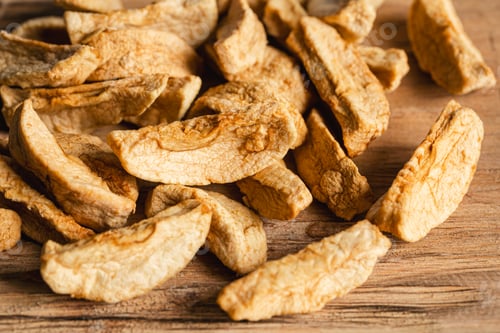 Preview: Homemade dried organic apple sliced on wood background.