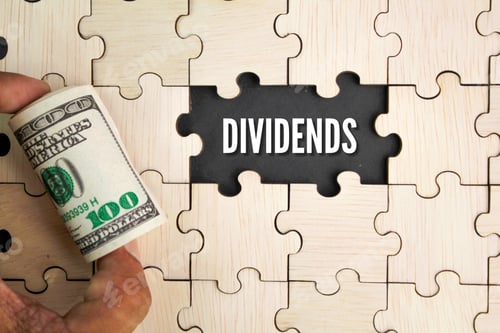 Preview: wooden puzzle and a roll of paper money with the word dividends.