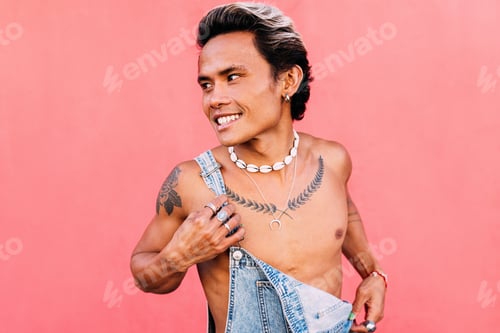Preview: Young smiling man in denim overalls looking away outdoors
