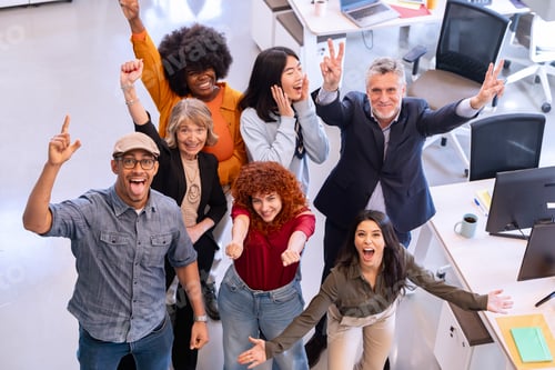 Preview: Happy business people smiling and celebrating in the office.