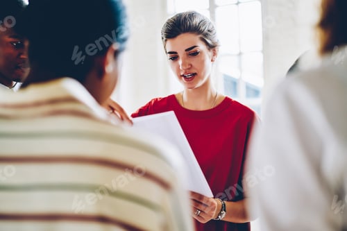 Preview: Diligent woman reading document to multiracial group of people