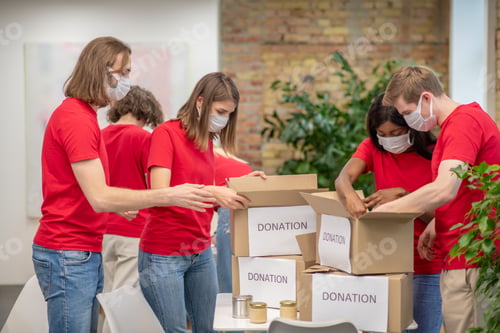 Preview: Young volunteers in red tshirts at work in a distribution point