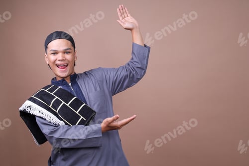 Preview: Attractive Young Asian Man Wearing Muslim Clothes Smiling And Presenting Ads On The Side