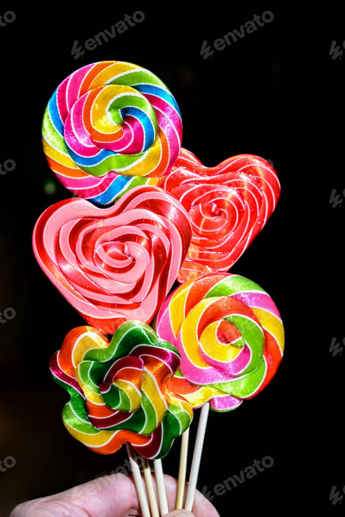Preview: Top view of three multicolored lollipops isolated on dark blue background. Pin-up style
