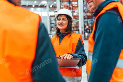 Preview: Warehouse workers discussing logistics with digital tablet