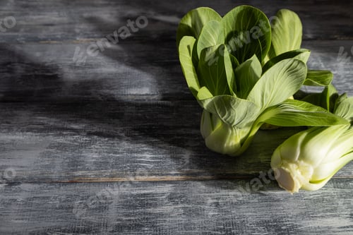 Preview: Fresh green bok choy or pac choi chinese cabbage on a gray wooden background. Side view, copy space.