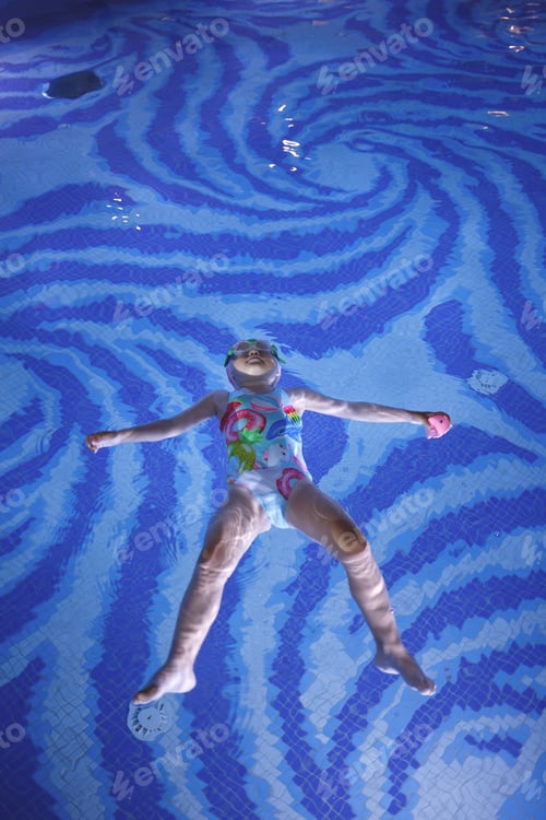 Preview: little cute girl swims in the pool