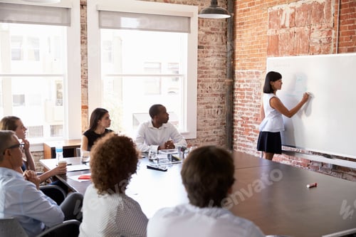 Preview: Businesswoman At Whiteboard Giving Presentation In Boardroom