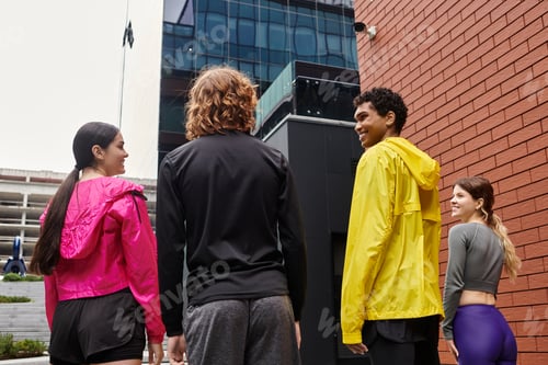 Preview: Young athletes gather in vibrant outfits, preparing for an outdoor workout in the city