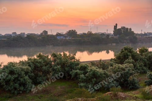 Preview: Coast of calm flat river at dawn