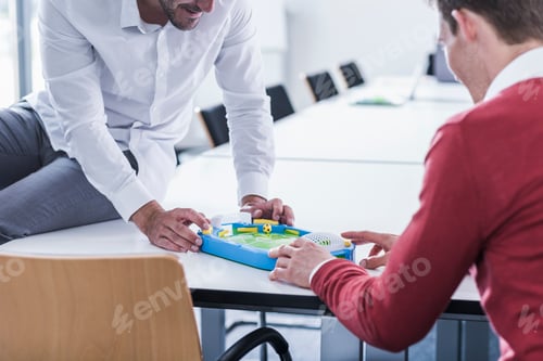 Preview: Two colleagues in office playing foosball