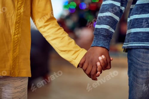 Preview: Close-up of African American boy and girl holding hands during Christmas day.