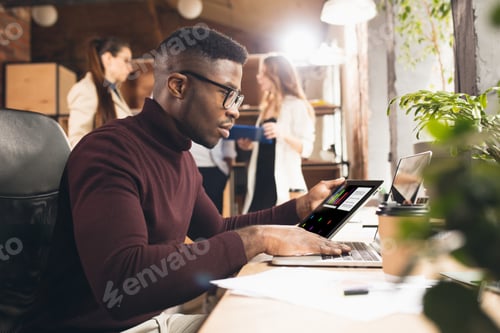 Preview: Colleagues working together in modern office using devices and gadgets during negotiations