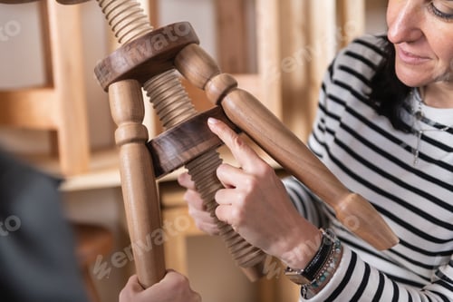 Preview: Furniture designer checking quality of a finished wooden chair