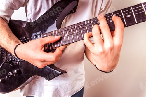 Preview: Close-up of the hands of a guitarist performing a song while pressing the strings.