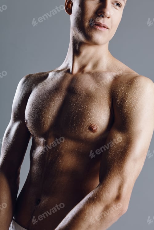 Preview: portrait of a bodybuilder with a pumped-up torso on a gray background closeup cropped view of a