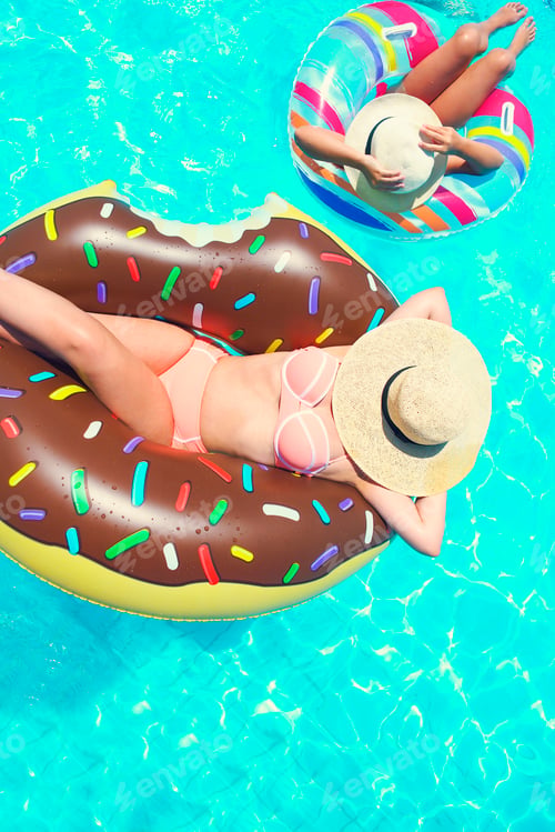 Preview: Two people mom and child relaxing on donut in the pool summer holiday
