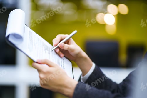 Preview: A man signs a contrac, legal or business agreements. Male hand with pen makes notes.