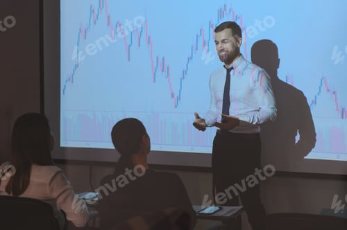 Preview: Man is standing near projector and showing graphs and business graphs.