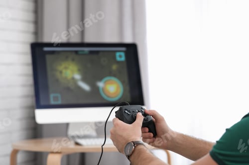 Preview: Young man playing video game at home, closeup