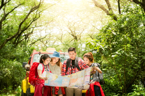 Preview: Couple or friends navigating together smiling happy during camping travel hike outdoors in forest.